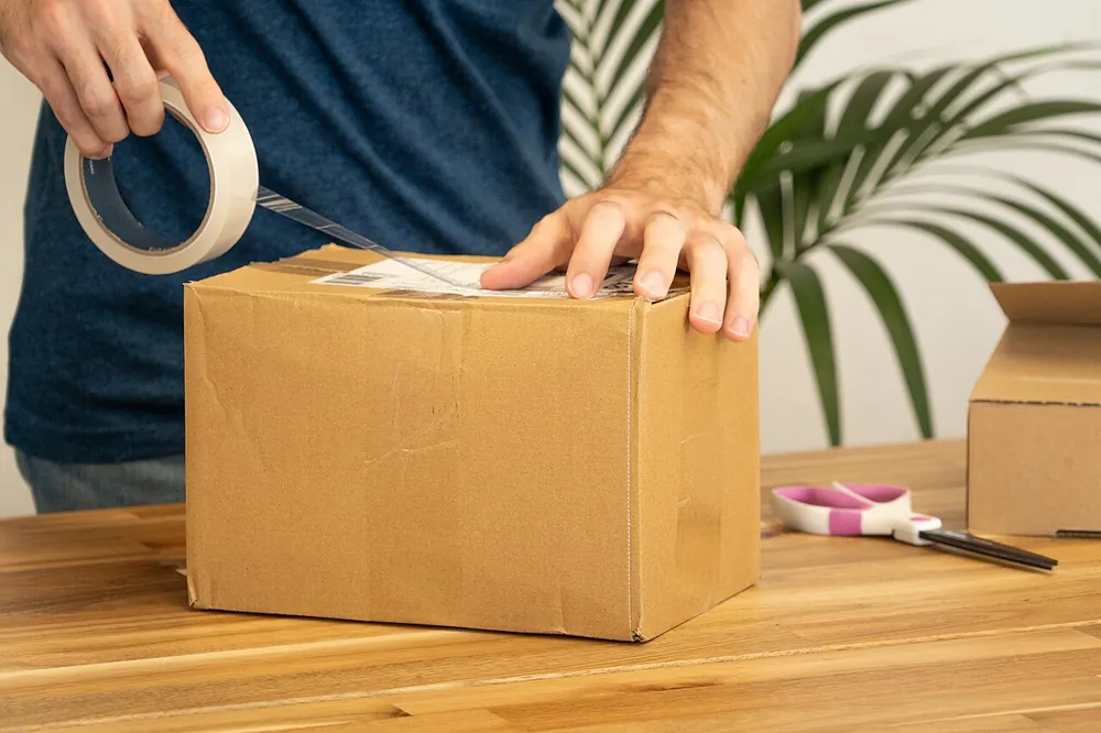 Worker attaching a shipping label to a parcel